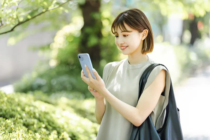 外出先でスマートフォンを確認する飼い主